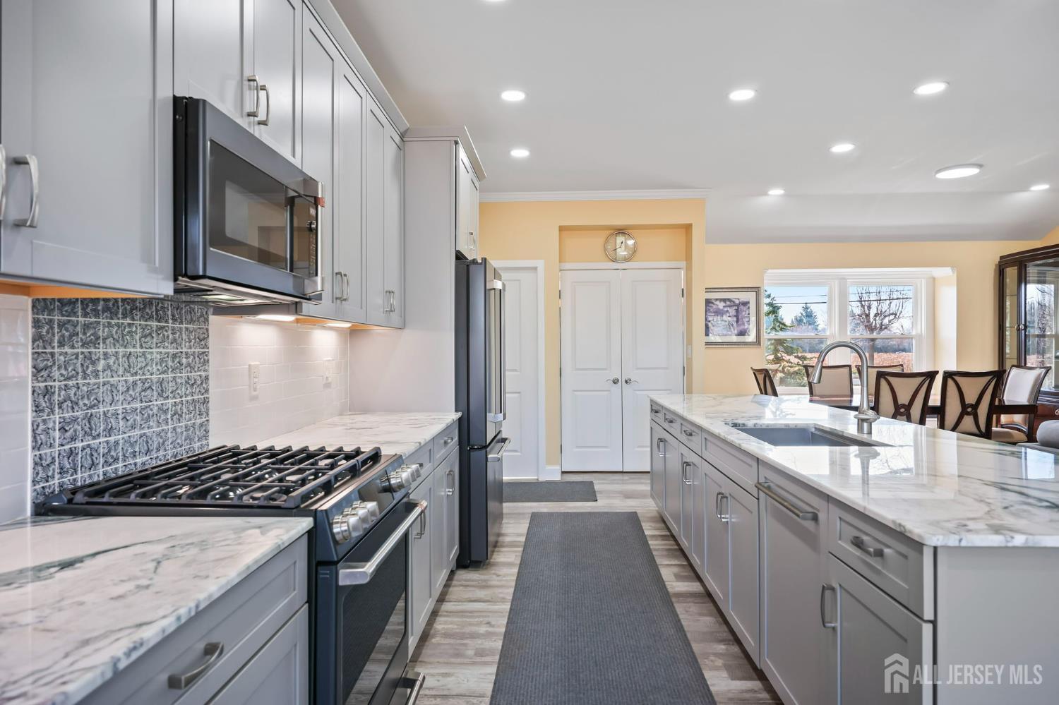 568 Village Road West Windsor, NJ 08550 - Photo 9 of 43 a kitchen with stainless steel appliances granite countertop a stove a sink and a microwave