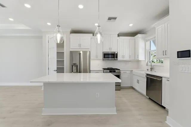a large kitchen with cabinets and stainless steel appliances