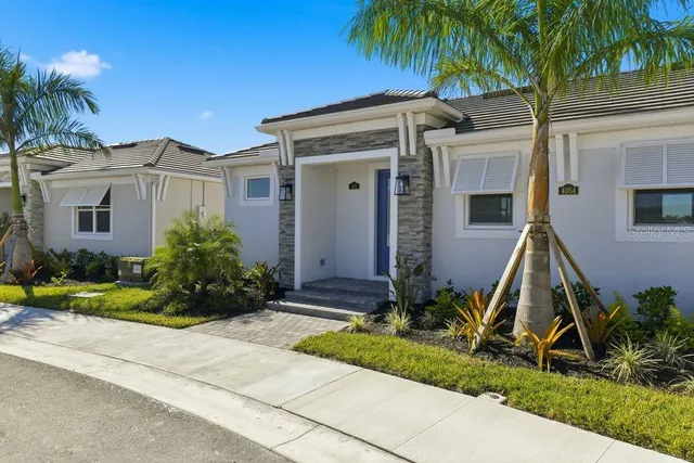 a view of a house with a small yard and palm trees