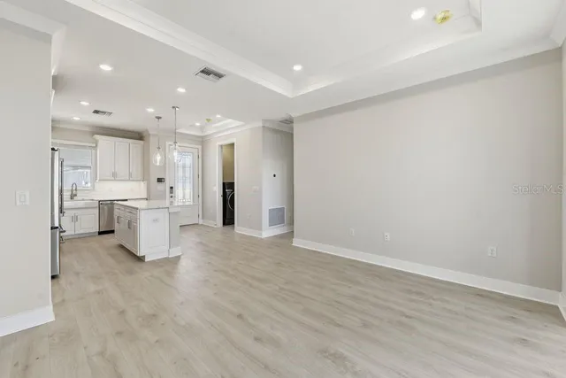 a view of a kitchen with refrigerator and white cabinets