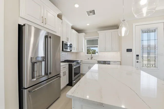 a kitchen with stainless steel appliances a refrigerator sink and cabinets