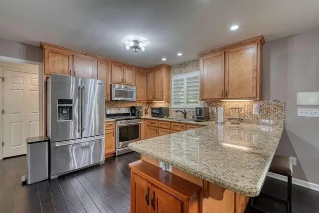 a dining room with stainless steel appliances a dining table and chairs
