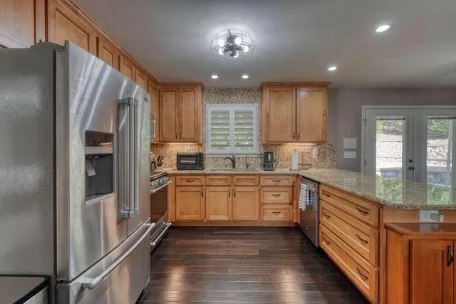 a bathroom with a granite countertop sink toilet and shower