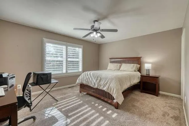 a spacious bedroom with a bed and a chandelier