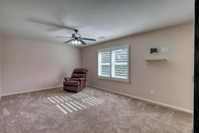 a view of a house with a small yard and a large tree