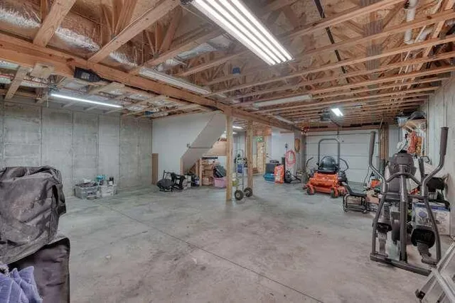 a view of a yard in front of a house with plants and large tree