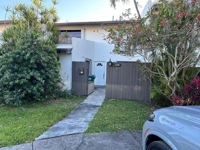 a view of backyard with potted plants and a large tree