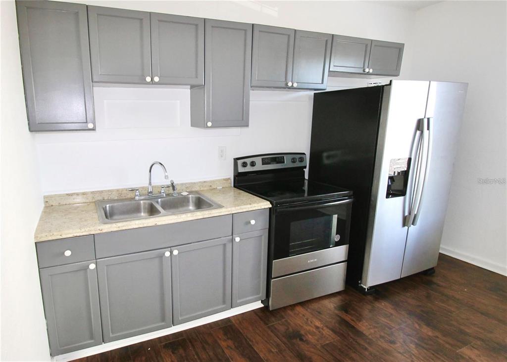 610 Dundee Road, Unit 1 Dundee, FL 33838 - Photo 11 of 28 a kitchen with a sink and a refrigerator
