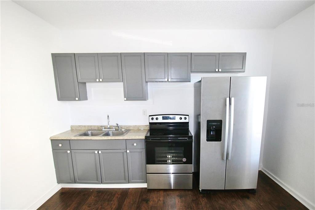 610 Dundee Road, Unit 1 Dundee, FL 33838 - Photo 10 of 28 a kitchen with a refrigerator sink and cabinets