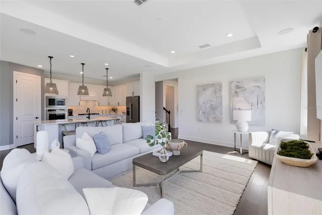 a living room with furniture a flat screen tv and a dining table