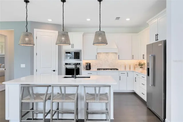a kitchen with white cabinets and appliances