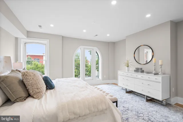 a bed room with a bed mirror and a window