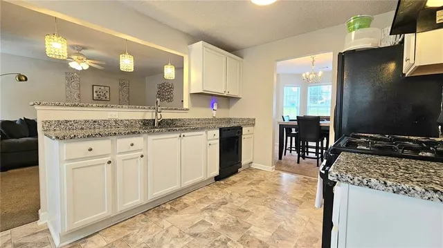 a kitchen with a stove a sink a dining table and chairs