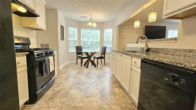 a kitchen with stainless steel appliances granite countertop a stove a sink and a microwave