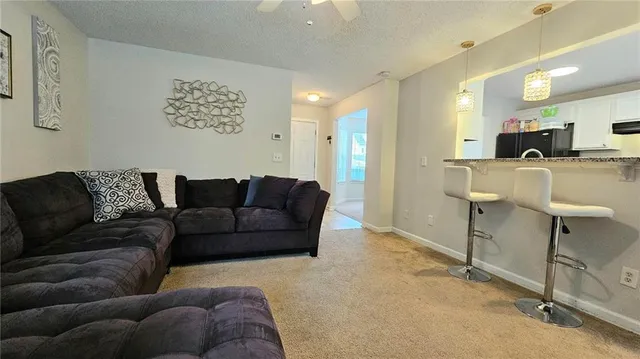 a living room with furniture a flat screen tv and a table