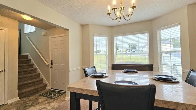 a dining room with furniture and a floor to ceiling window