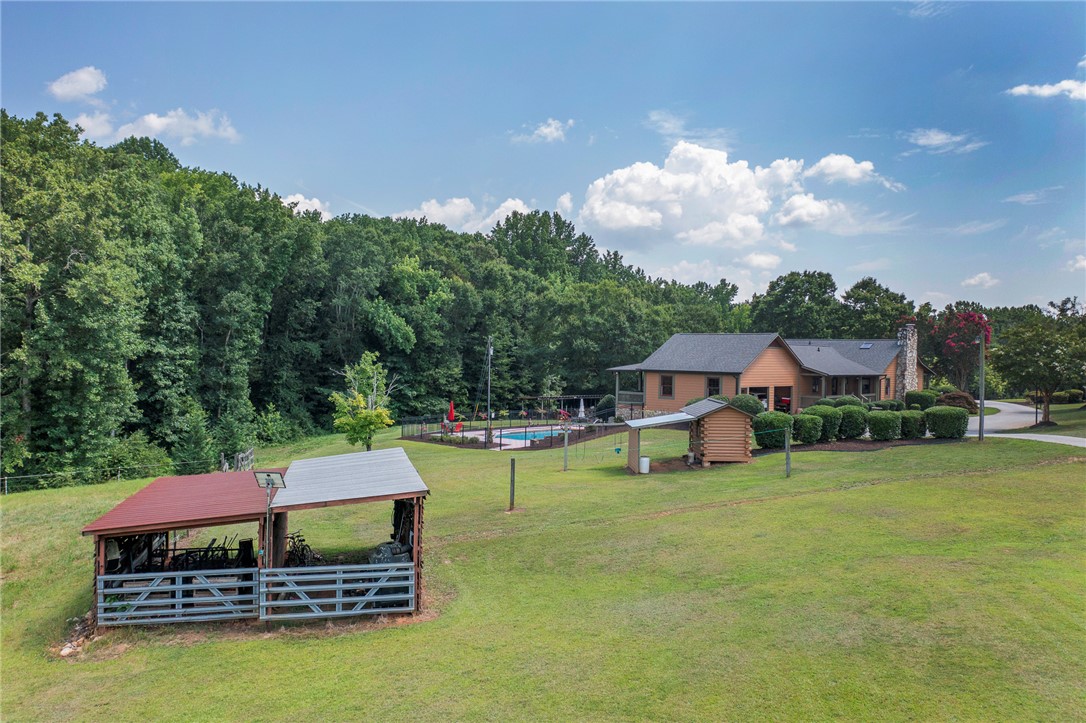 911 State Rd S-4-203 Belton, SC 29627 - Photo 47 of 49 A private oasis awaits, featuring a fenced pool and vast green spaces for outdoor living.