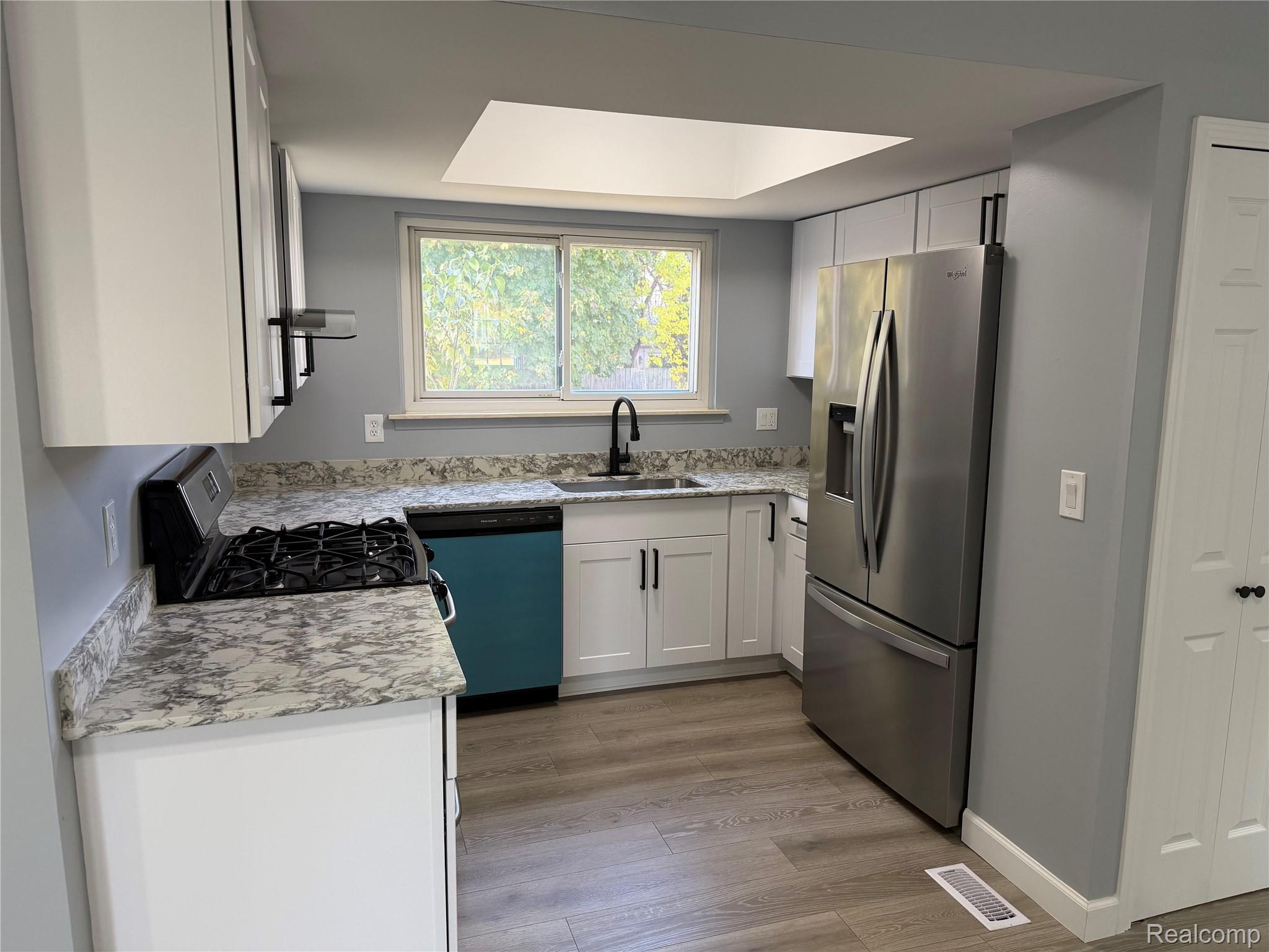 20698 Coachwood Road Riverview, MI 48193 - Photo 8 of 37 Kitchen featuring appliances with stainless steel finishes, white cabinetry, and light wood-type flooring