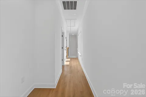 a view of a brick house with a yard and large trees