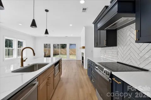 a kitchen with stainless steel appliances granite countertop a lot of white cabinets