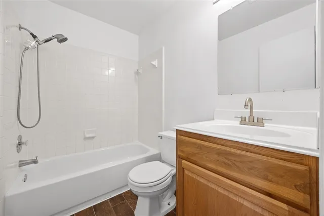 an empty room with wooden floor ceiling fan and windows