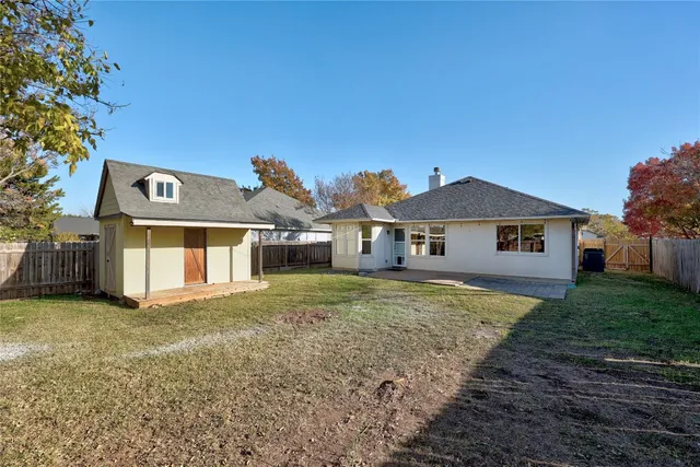 a view of a yard with wooden fence