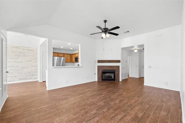 a view of an empty room with a fireplace and a window
