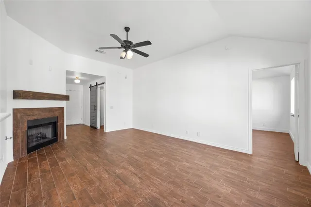 a view of empty room with wooden floor and fireplace