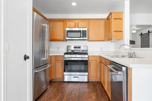 a kitchen with granite countertop a sink stove and refrigerator