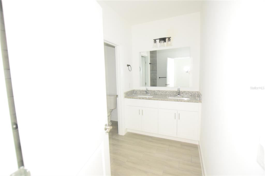 460 Lake Shore Parkway Davenport, FL 33896 - Photo 25 of 27 a bathroom with a sink and a mirror