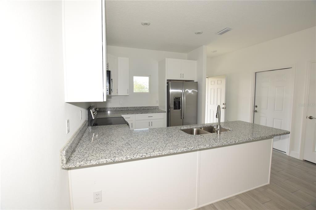 460 Lake Shore Parkway Davenport, FL 33896 - Photo 4 of 27 a kitchen with granite countertop a sink and a granite counter tops