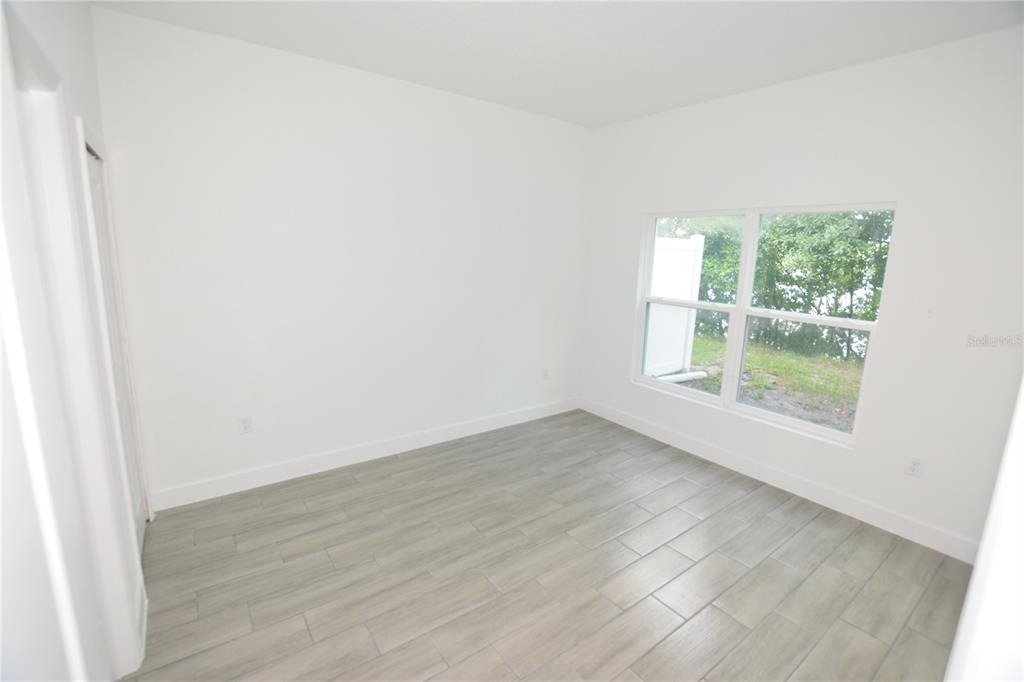 460 Lake Shore Parkway Davenport, FL 33896 - Photo 8 of 27 an empty room with wooden floor and windows