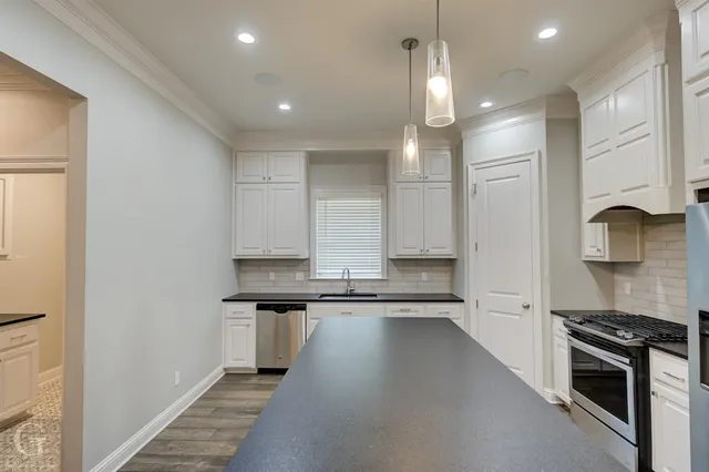 a kitchen with stainless steel appliances granite countertop a stove a sink and a refrigerator