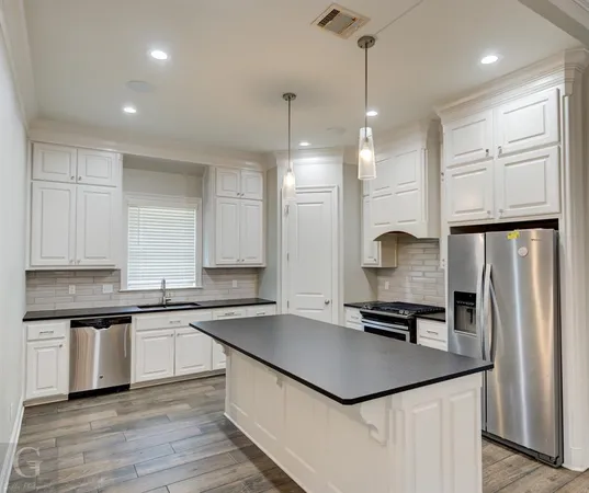a kitchen with stainless steel appliances a sink stove and refrigerator