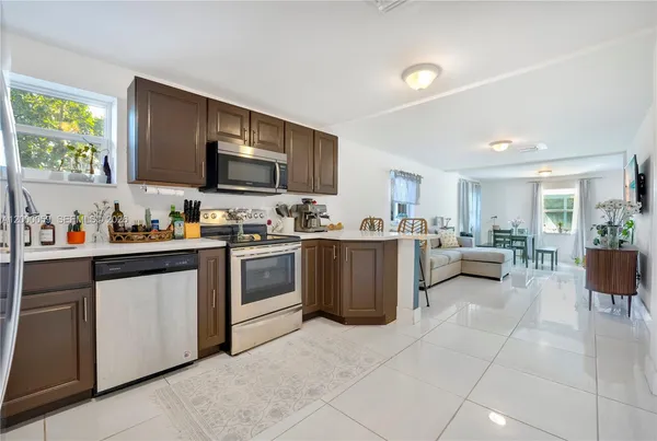 a kitchen with a sink a counter top space appliances and cabinets