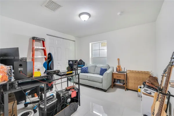 a living room with furniture a flat screen tv and a window