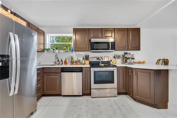 a kitchen with stainless steel appliances a stove microwave and refrigerator