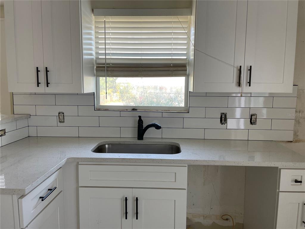 5200 3rd Avenue South St. Petersburg, FL 33707 - Photo 12 of 47 a kitchen with a sink a window and cabinets