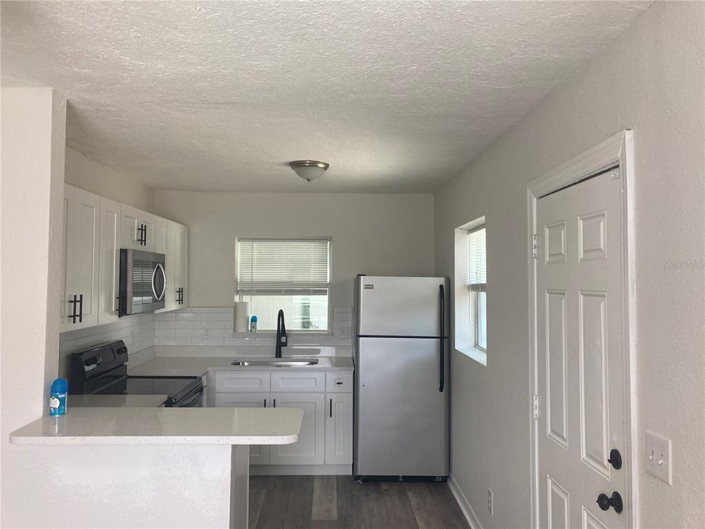 5200 3rd Avenue South St. Petersburg, FL 33707 - Photo 22 of 47 a kitchen with a refrigerator a sink and a stove top oven