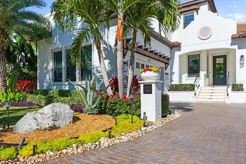 a front view of a house with a yard and fountain