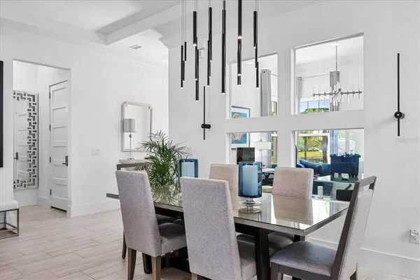 a living room with furniture a chandelier and a dining table