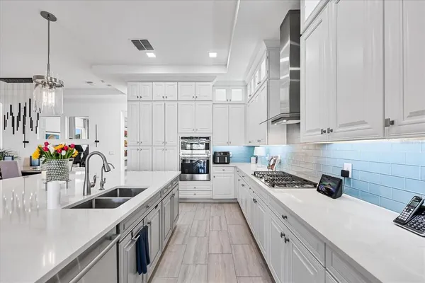 a kitchen with white cabinets and stainless steel appliances