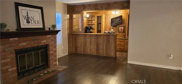 a view of a livingroom with wooden floor and a fireplace