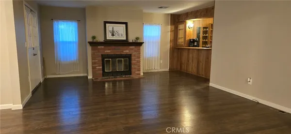 a view of a livingroom with wooden floor and a fireplace