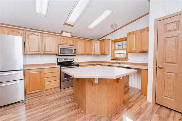 a kitchen with stainless steel appliances granite countertop a sink a stove and refrigerator