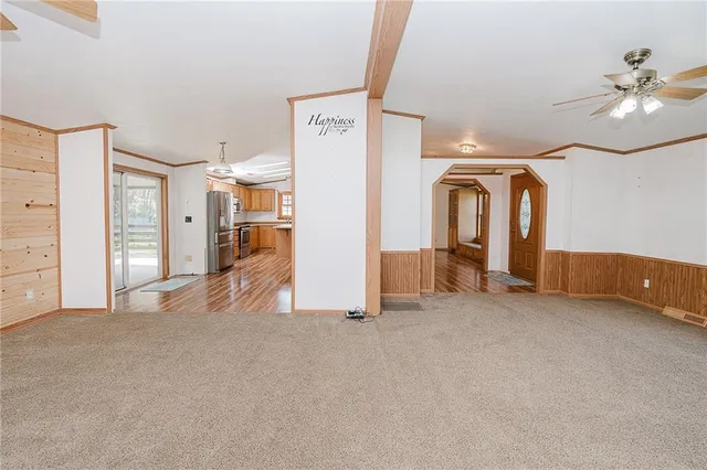 an empty room with windows and fan