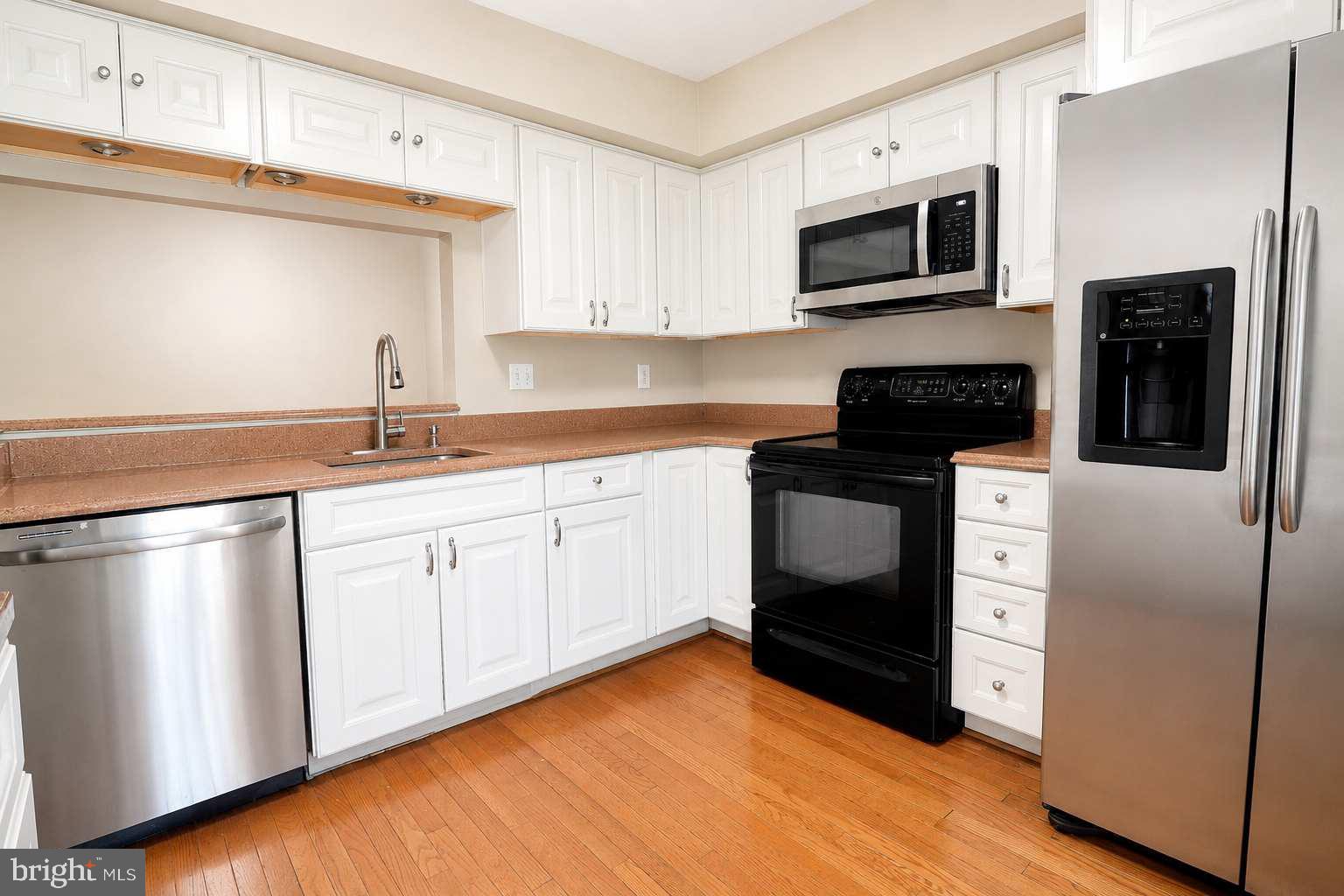 9054 Canterbury Riding, Unit 147 Laurel, MD 20723 - Photo 4 of 15 a kitchen with stainless steel appliances a stove microwave and sink