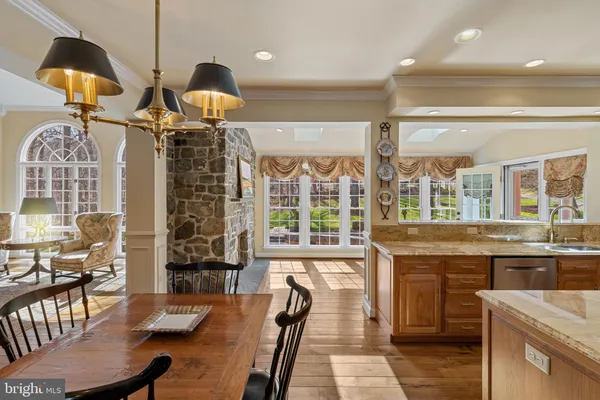a view of a dining room and livingroom with furniture wooden floor a chandelier