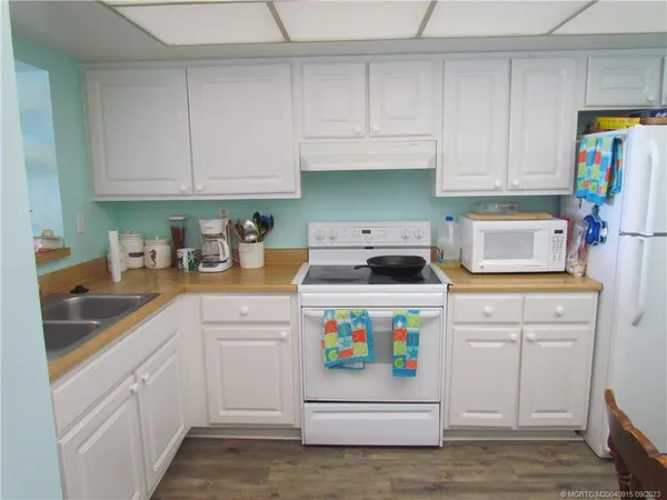 a kitchen with white cabinets and white appliances