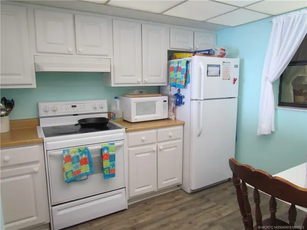 a kitchen with refrigerator and white cabinets